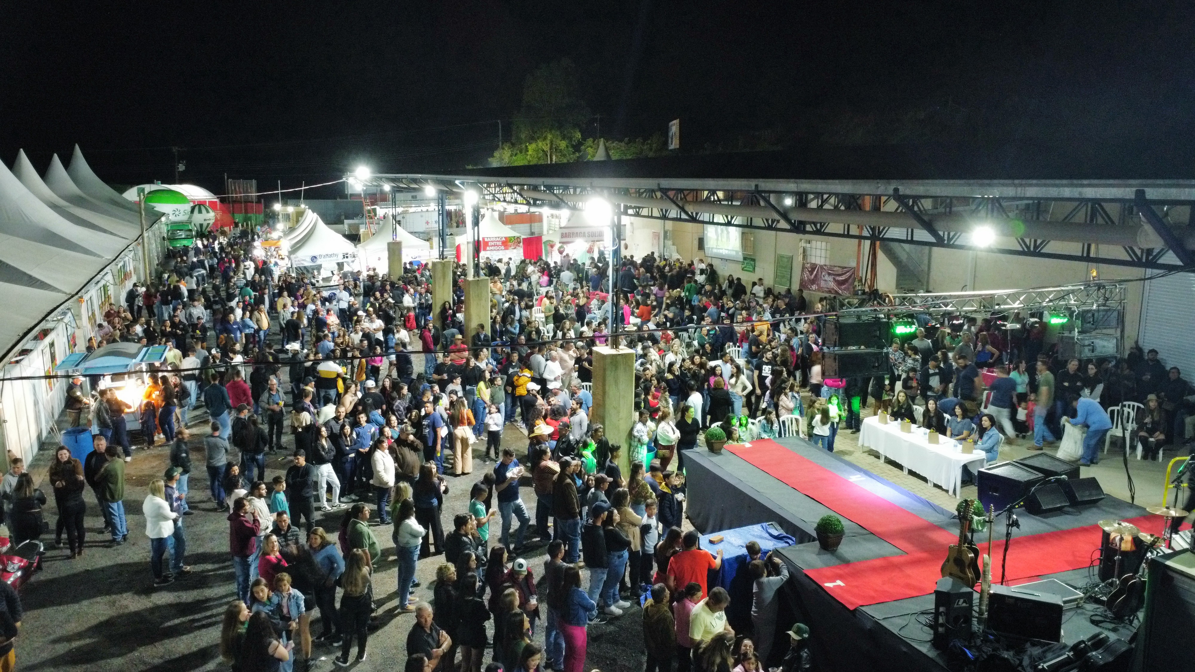 Salão da feira com expositores e visitantes